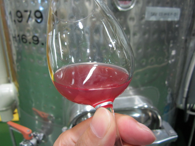 グラスに入れたピンク色の果汁
